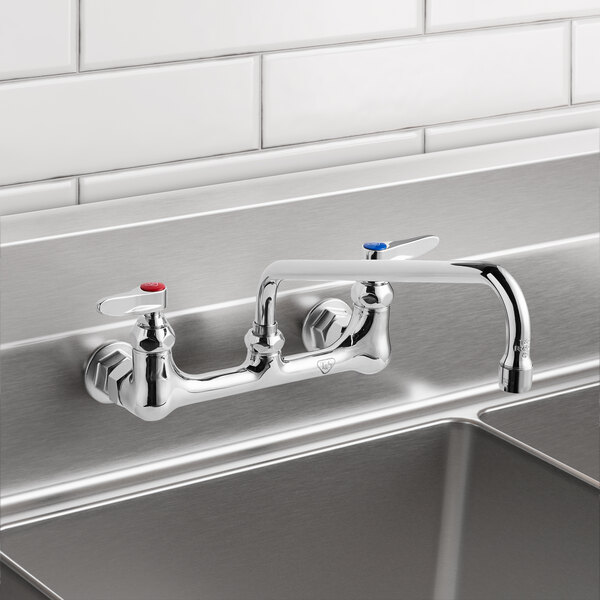 A T&S silver metal wall mounted pantry faucet with two handles and a 12" swing nozzle.