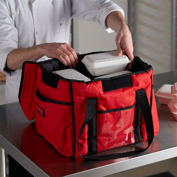 A man using a red Cambro Sandwich GoBag to hold food.