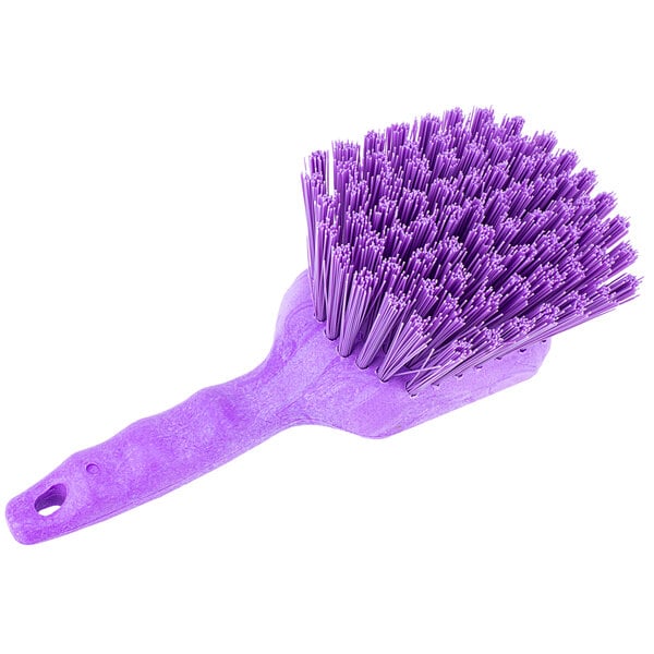 A close-up of a Carlisle Sparta purple pot scrub brush with a long handle.