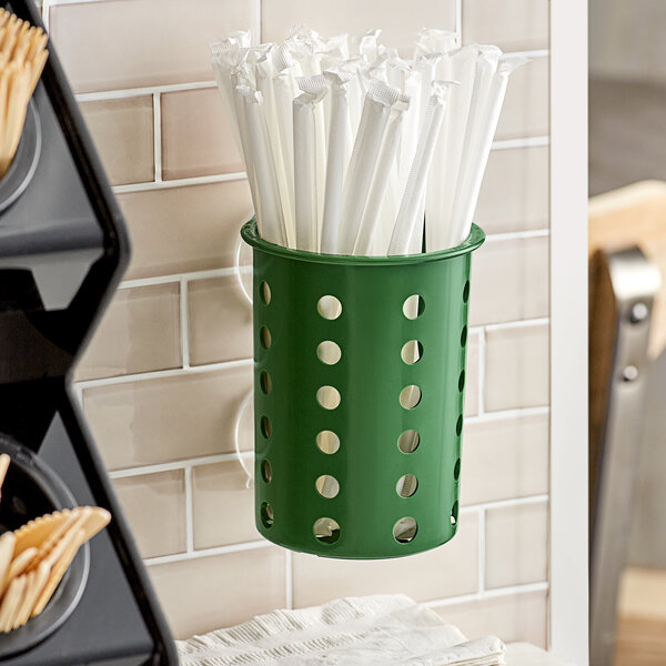 A Hunter green Steril-Sil flatware cylinder holding white and green straws.