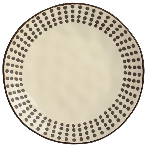 A white stoneware salad plate with black dots on it.
