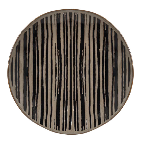 A tan stoneware salad plate with a black and white striped surface.