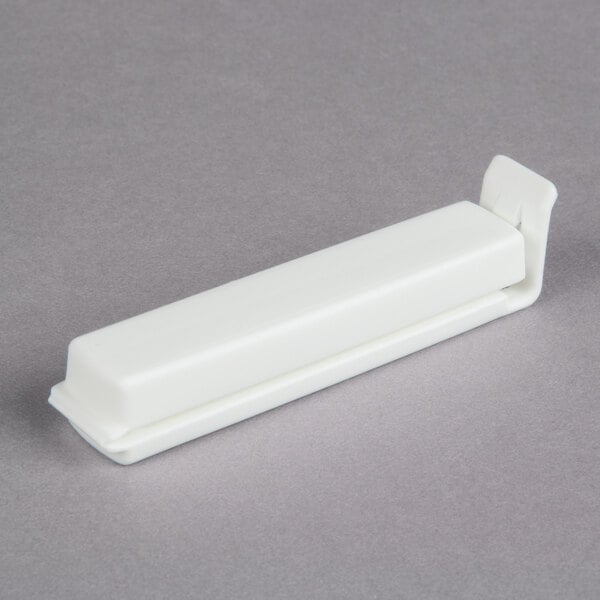 A white plastic strip with a small handle on one end.