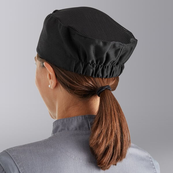 A woman wearing a black Choice chef hat with mesh top.