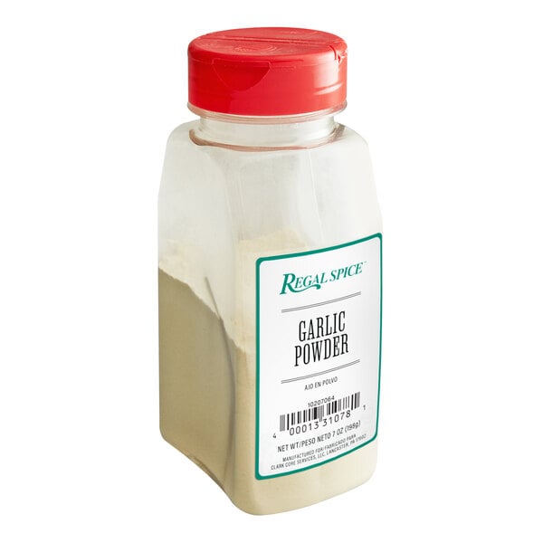 A clear plastic container of Regal Garlic Powder with a white label and a red lid.