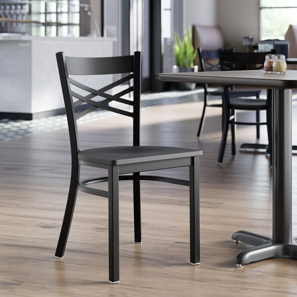 A black metal chair with a cross back design and a black wood seat.