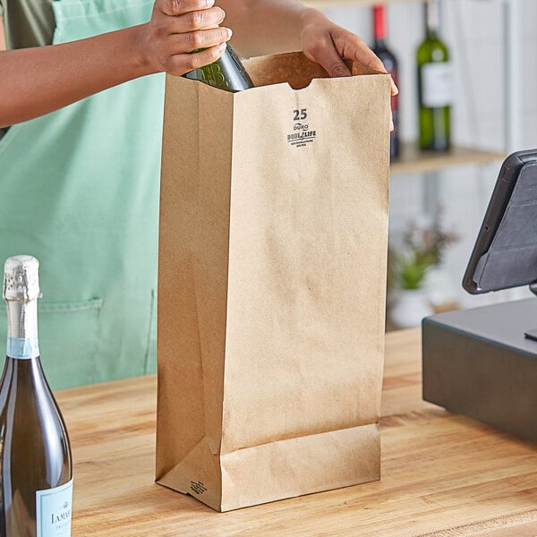 A woman pouring wine into a brown paper bag on a counter.