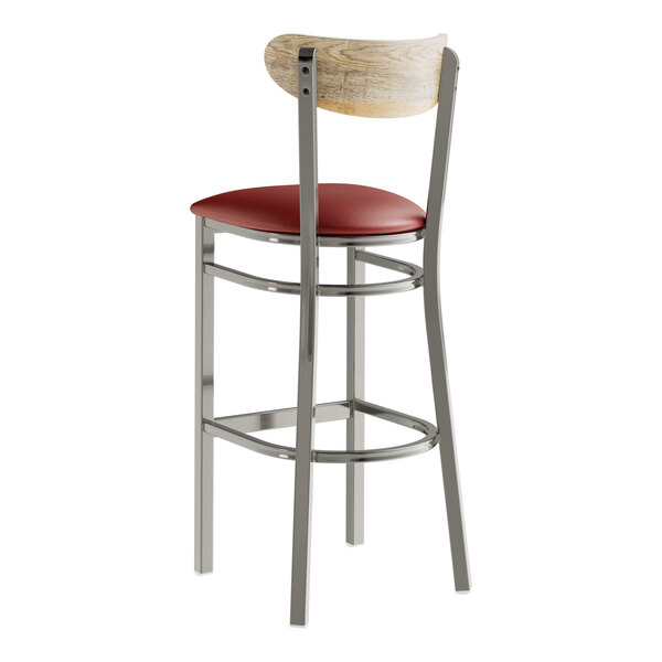 A Lancaster Table & Seating bar stool with a red vinyl cushion and driftwood back.