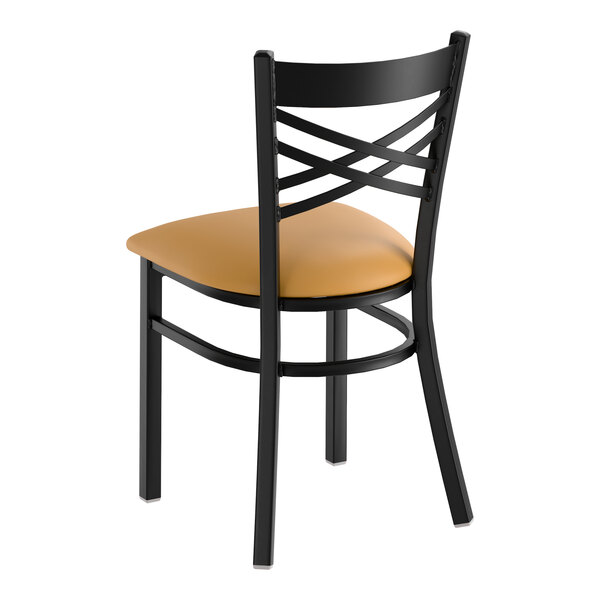 A black metal cross back chair with a light brown vinyl padded seat.
