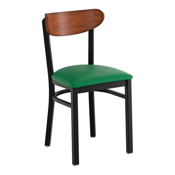 A black metal chair with a green vinyl seat and an antique walnut wood backrest.