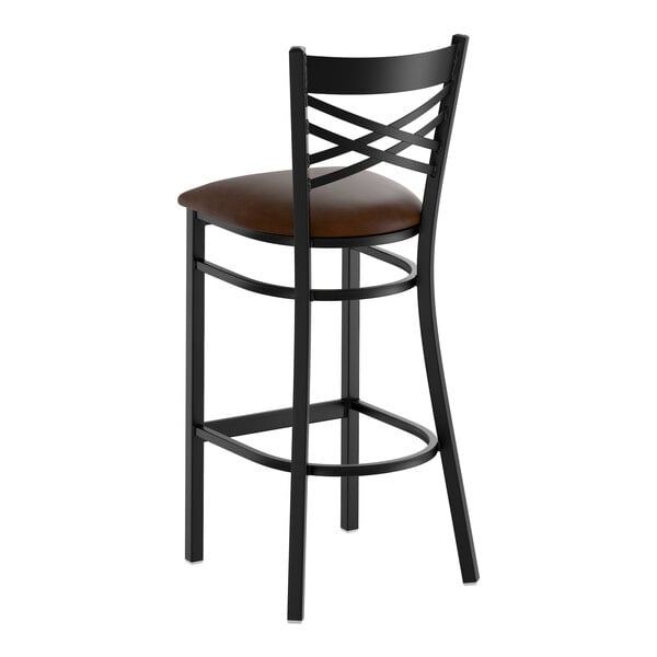 A black metal bar stool with a cross back design and a dark brown vinyl padded seat.