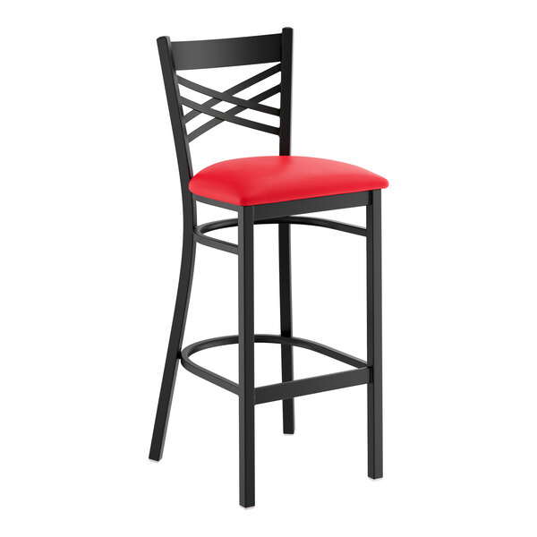 A black metal bar stool with a cross back design and a red vinyl padded seat.