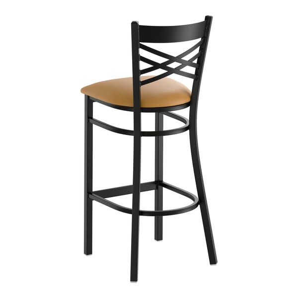 A black metal bar stool with a cross back design and a light brown vinyl padded seat.