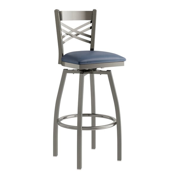 A Lancaster Table & Seating metal swivel bar stool with a navy blue cushion.