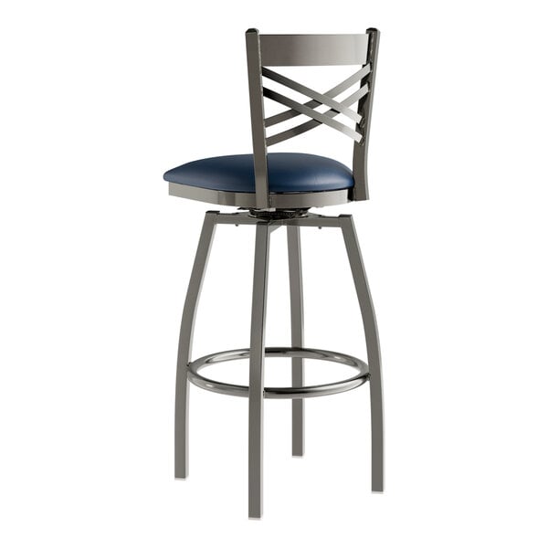 A Lancaster Table & Seating metal bar stool with a navy blue cushion.
