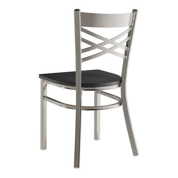 A Lancaster Table & Seating metal cross back chair with a black wood seat.