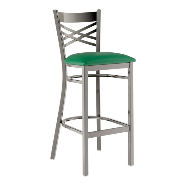 A metal bar stool with a cross back design and a green vinyl padded seat.