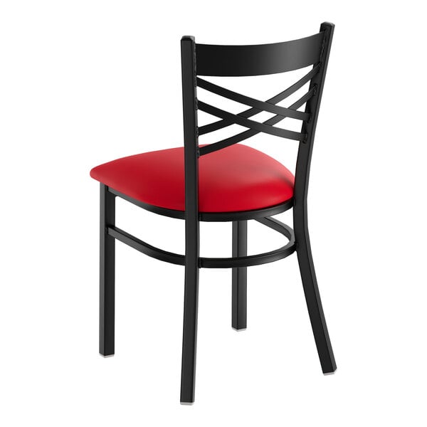 A black metal cross back chair with a red vinyl padded seat.
