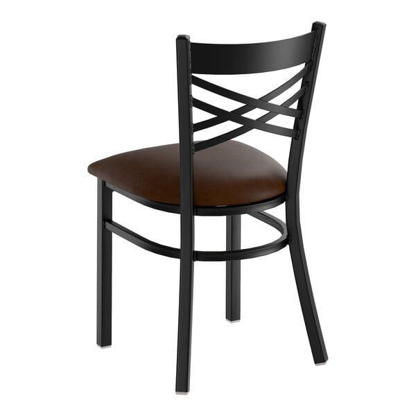 A black metal chair with a cross back design and a dark brown vinyl padded seat.