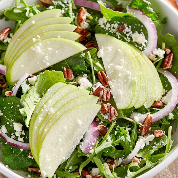 A bowl of salad with sliced Granny Smith apples and pecans.