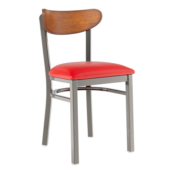A Lancaster Table & Seating Boomerang chair with red vinyl seat and wooden back and metal legs.