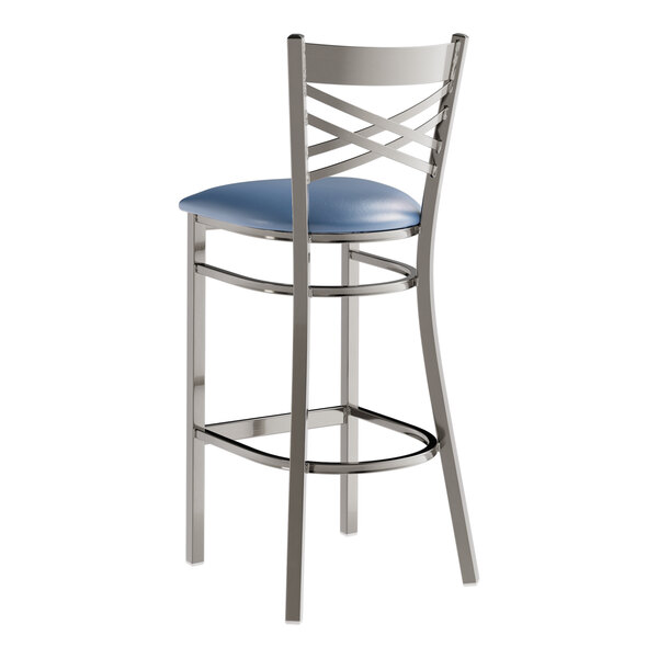 A metal bar stool with a cross back design and a navy blue padded vinyl seat.