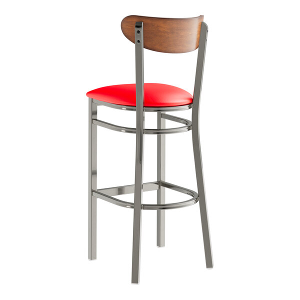 A Lancaster Table & Seating bar stool with a red vinyl seat and wood back.