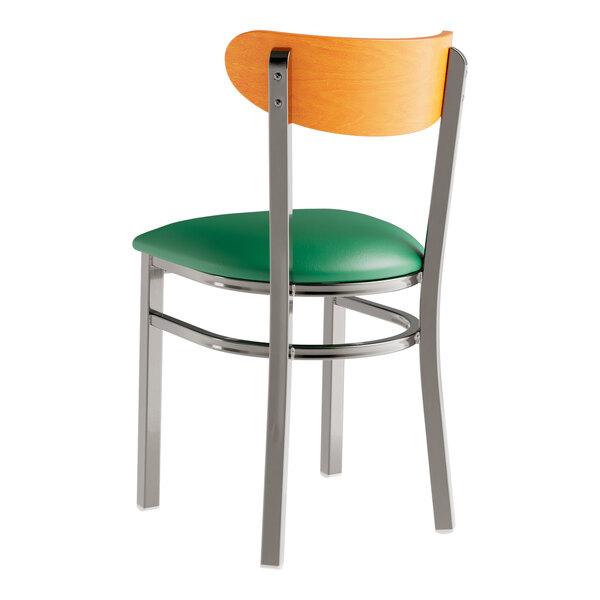 A Lancaster Table & Seating chair with a green vinyl seat and clear metal frame and cherry wood back.