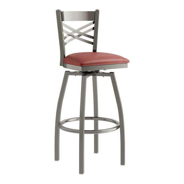 A Lancaster Table & Seating swivel bar stool with a burgundy vinyl cushion on the seat.