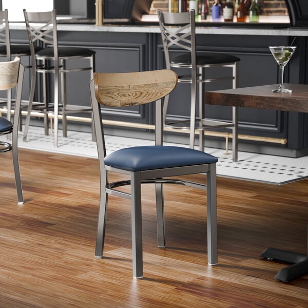 A metal chair with a navy vinyl seat and a driftwood-finished wooden backrest.