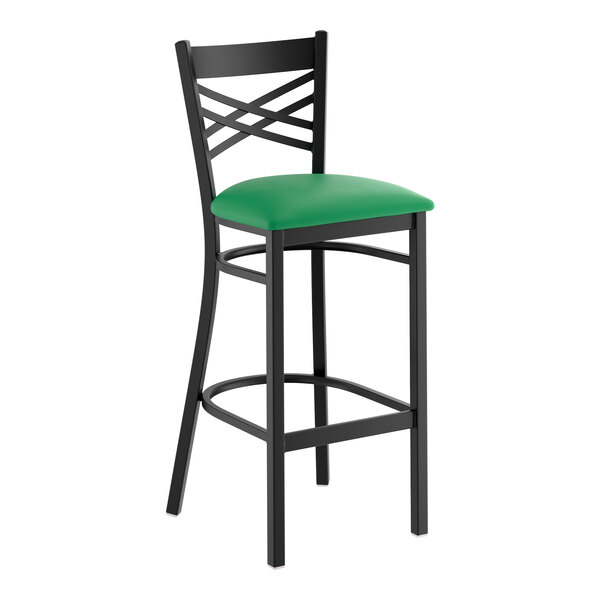 A black metal bar stool with a cross back design and a green vinyl padded seat.