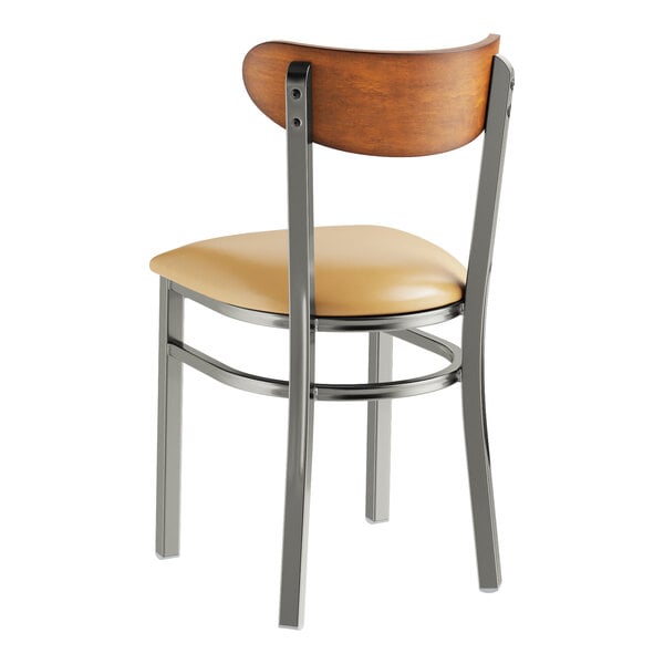 A Lancaster Table & Seating metal and wood chair with a light brown vinyl seat.