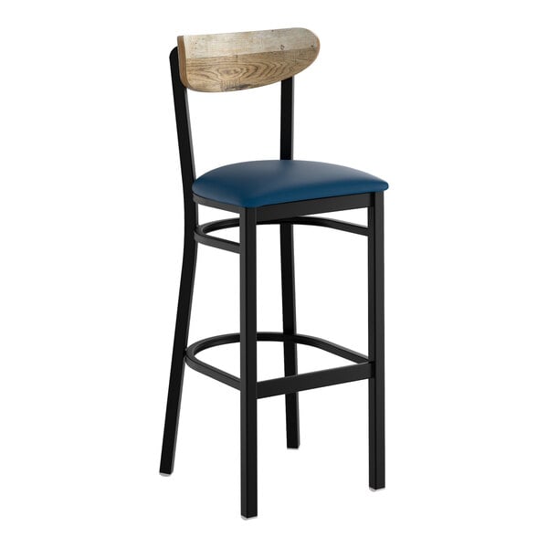 A bar stool with a black metal frame, navy vinyl seat, and a driftwood-finished wooden backrest.