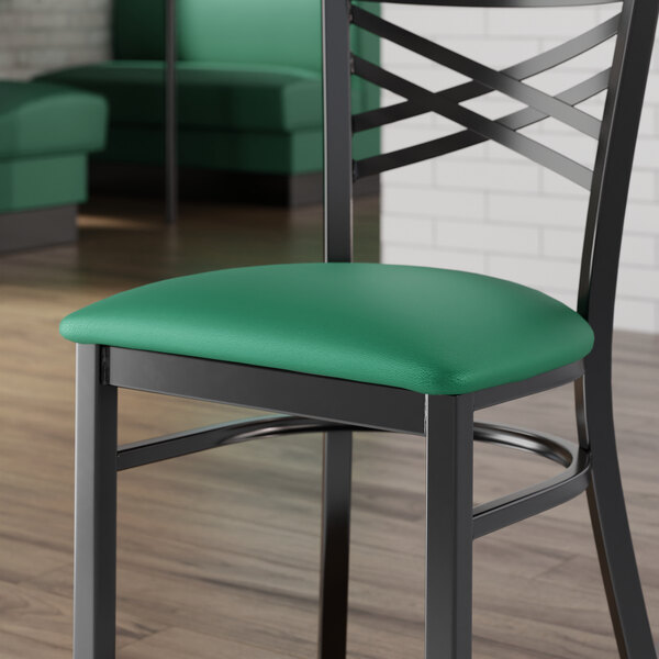 A Lancaster Table & Seating green vinyl padded seat on a black metal frame.