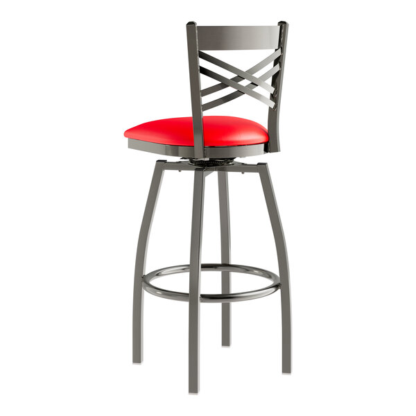 A Lancaster Table & Seating clear coat finish metal bar stool with a red padded seat.