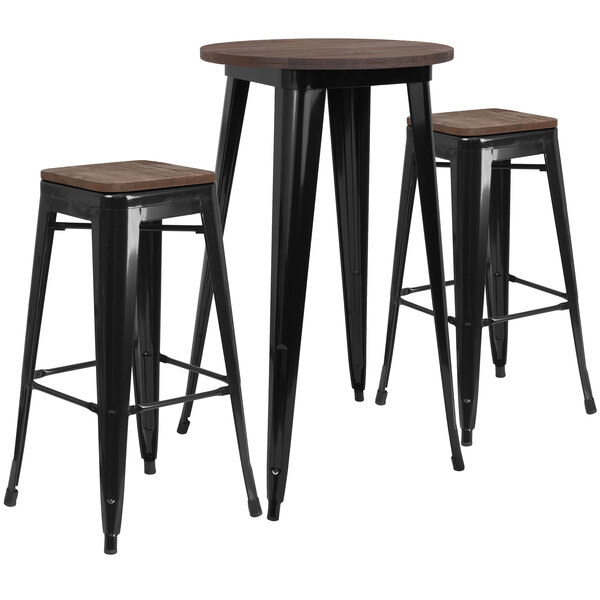 A Flash Furniture bar height table with a black galvanized steel top and wooden legs with two black backless stools.