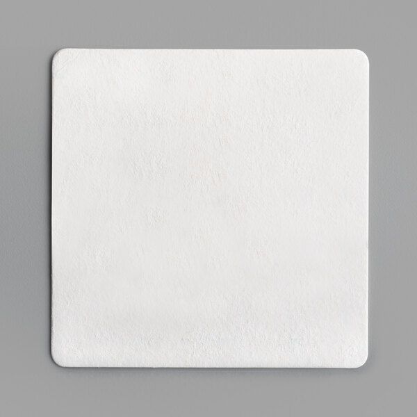 A white square object on a gray surface.