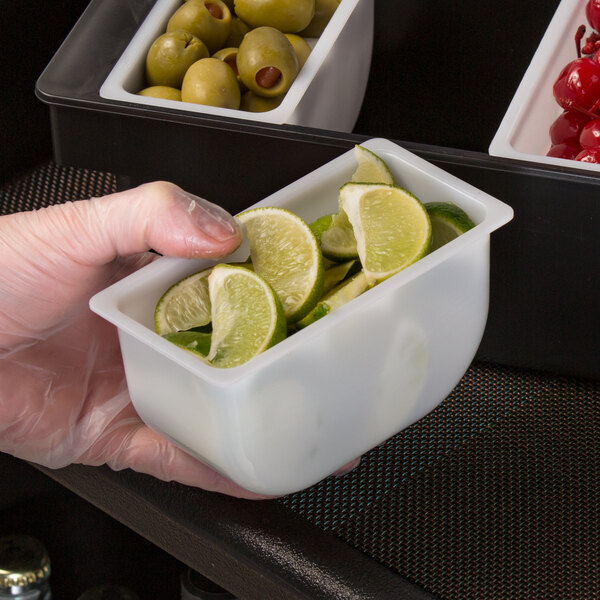 A Tablecraft condiment dispenser holding limes on a counter.