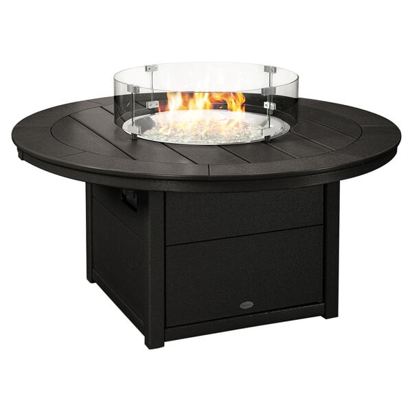 A black POLYWOOD fire pit table with a glass top over a fire.