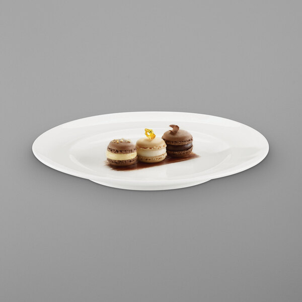 A RAK Porcelain ivory flat plate with three desserts on it.