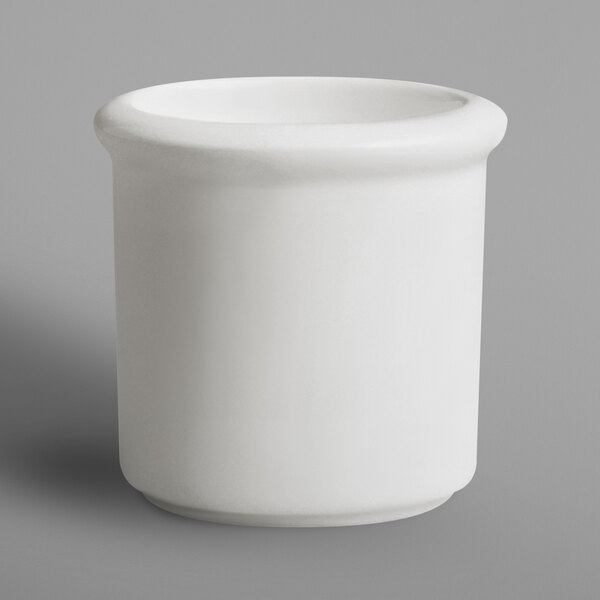 A white porcelain RAK toothpick holder with a white rim on a gray surface.