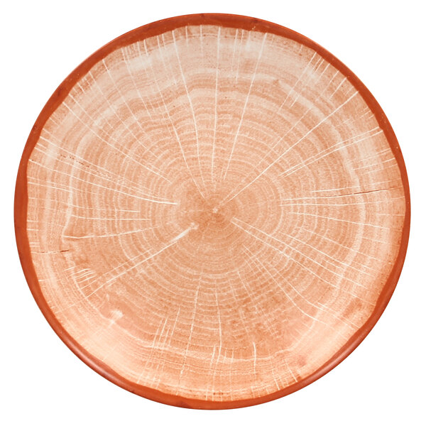 A close up of a RAK Porcelain Cedar Orange deep coupe plate with a tree trunk design.