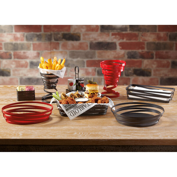 A gray metal wire sugar caddy on a table with food.