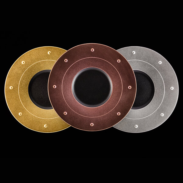 A group of circular metal discs with silver and black metal fusion designs.