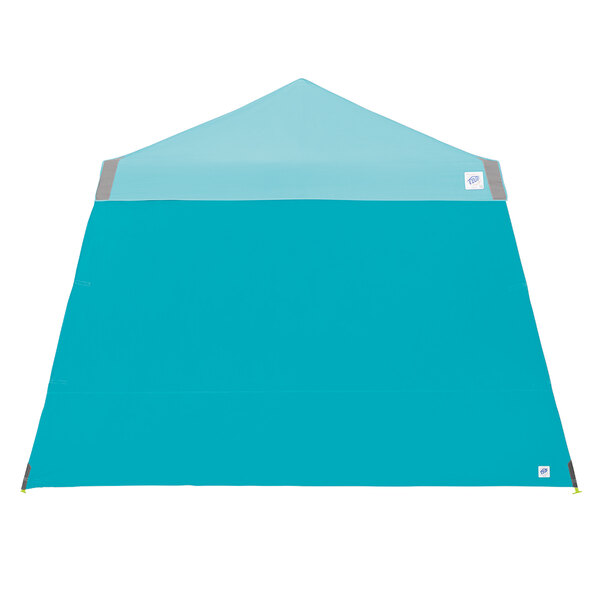 A blue tent sidewall with a grey roof and white stripe with blue triangle accents.