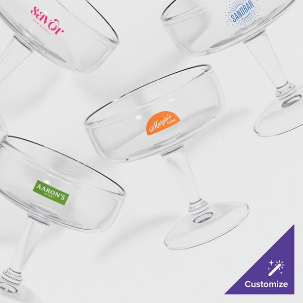 A close-up of a clear plastic margarita glass with pink writing on the side.