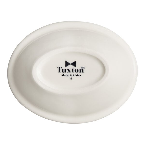 An oval-shaped, eggshell-colored china fruit or monkey dish with the Tuxton brand logo on the bottom.