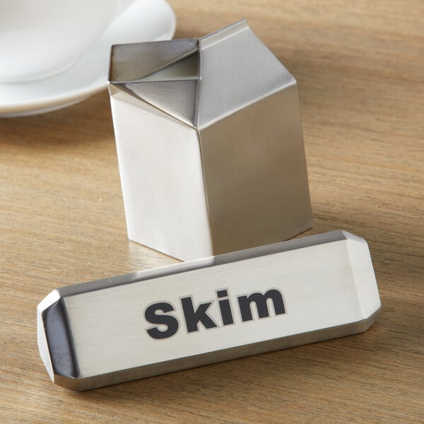 A silver American Metalcraft stainless steel table sign with "Milk / Cream / Skim" on it.