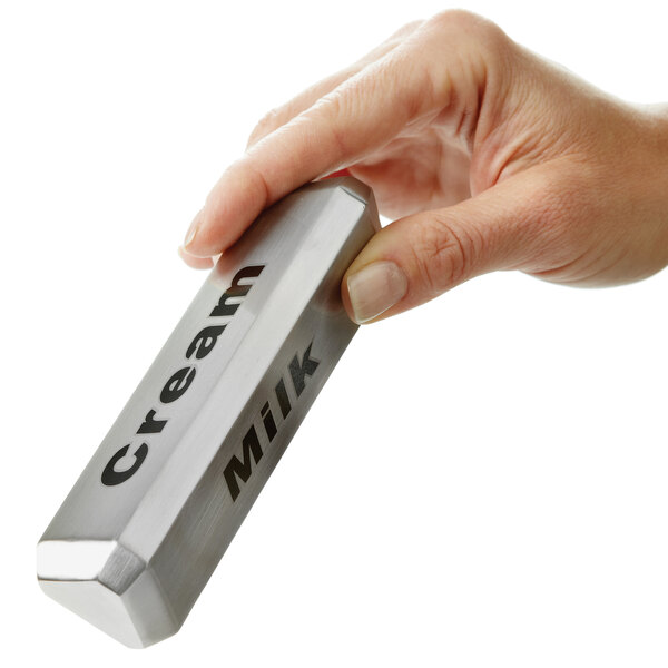 A person holding an American Metalcraft stainless steel tabletop sign with "Milk" printed.