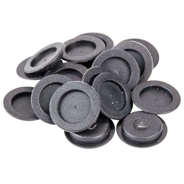 A pile of black round replacement plugs for salt and pepper shakers.